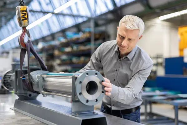 Técnico ajustando un sistema de bombeo en un entorno industrial, resaltando la precisión y el trabajo técnico en bombas.
