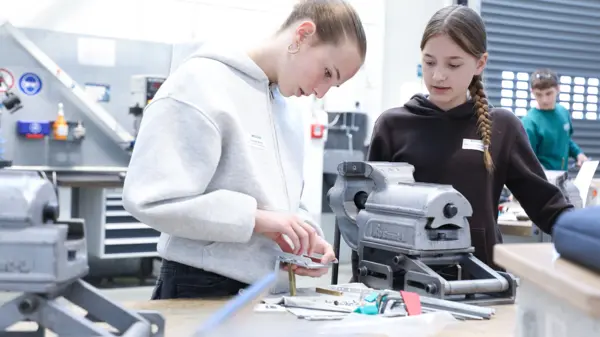 Two Girls’Day participants at NETZSCH workshop assembling mechanical parts, exploring technical apprenticeships in engineering.