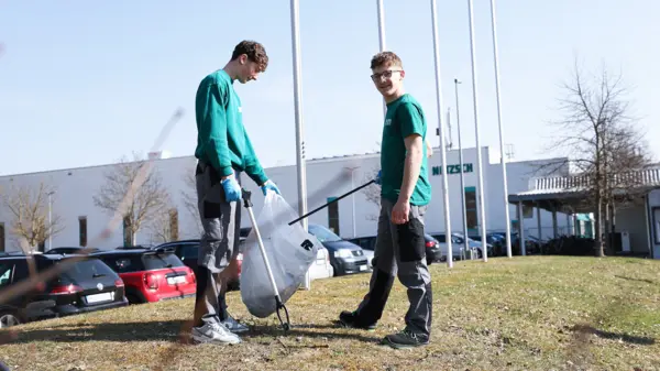 NETZSCH medewerkers ruimen zwerfvuil op rond de bedrijfscampus tijdens de "Rama Dama" milieucampagne, met groene shirts aan.