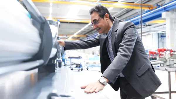 Peter Samraj, Global Product Line Manager NEMO®, inspecting industrial pumping equipment in a bright manufacturing facility, emphasizing quality and innovation.