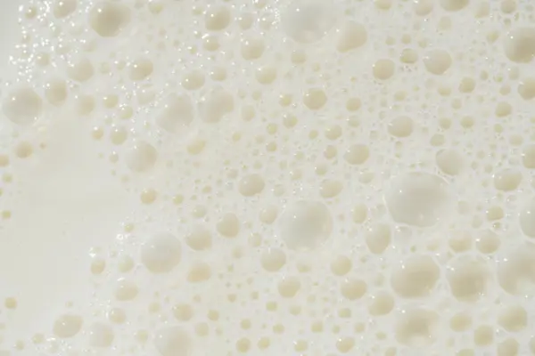 Close-up of a creamy, foamy hot starch solution with tiny bubbles, ideal for reliable pumping in paper production.