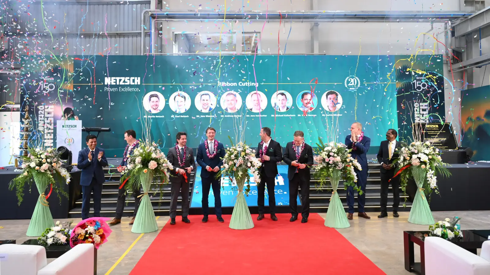 Celebration of NETZSCH's new production facility opening in Goa, featuring executives, floral arrangements, and confetti.