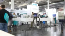 NETZSCH industrial pumps displayed at a trade show booth with visitors and technology demonstrations.