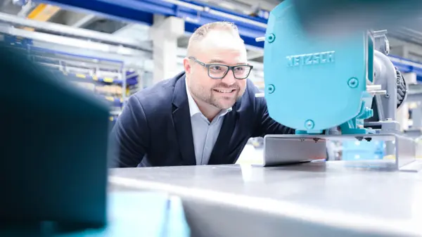 Stefan Schöberl inspecte une pompe à lobes rotatifs NETZSCH, mettant en évidence sa conception compacte et son efficacité pour diverses industries.