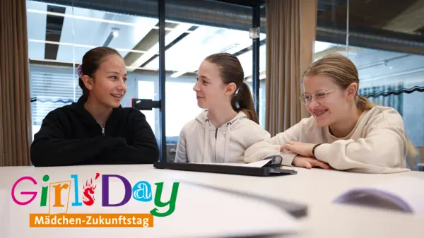 Three girls engage in conversation, smiling and sharing insights during Girls’Day at NETZSCH, showcasing future career opportunities in technology.