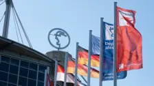 位于德国汉诺威的 INTERSCHUTZ 活动场馆外彩旗招展，晴空下的德国展览公司标志熠熠生辉。