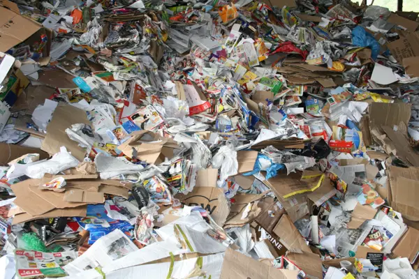 A chaotic pile of waste paper and cardboard, highlighting the complexities in recycling processes for paper production.