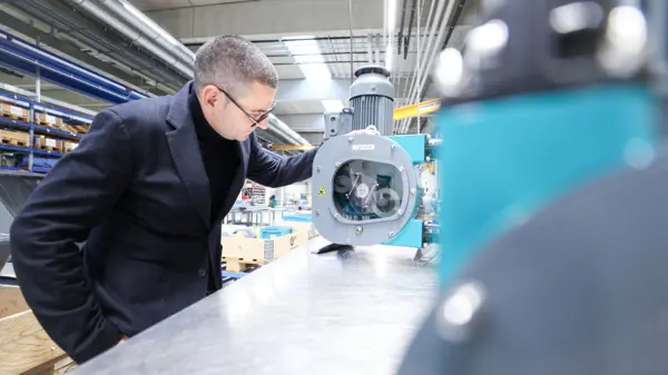 Een doelgerichte ingenieur inspecteert een NETZSCH PERIPRO® slangenpomp, met een robuust ontwerp voor veeleisende toepassingen.