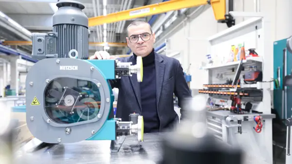David Gil, Global Productline Manager, staat zelfverzekerd naast een PERIPRO® slangenpomp, waarop geavanceerde pomptechnologie voor robuuste toepassingen wordt getoond.