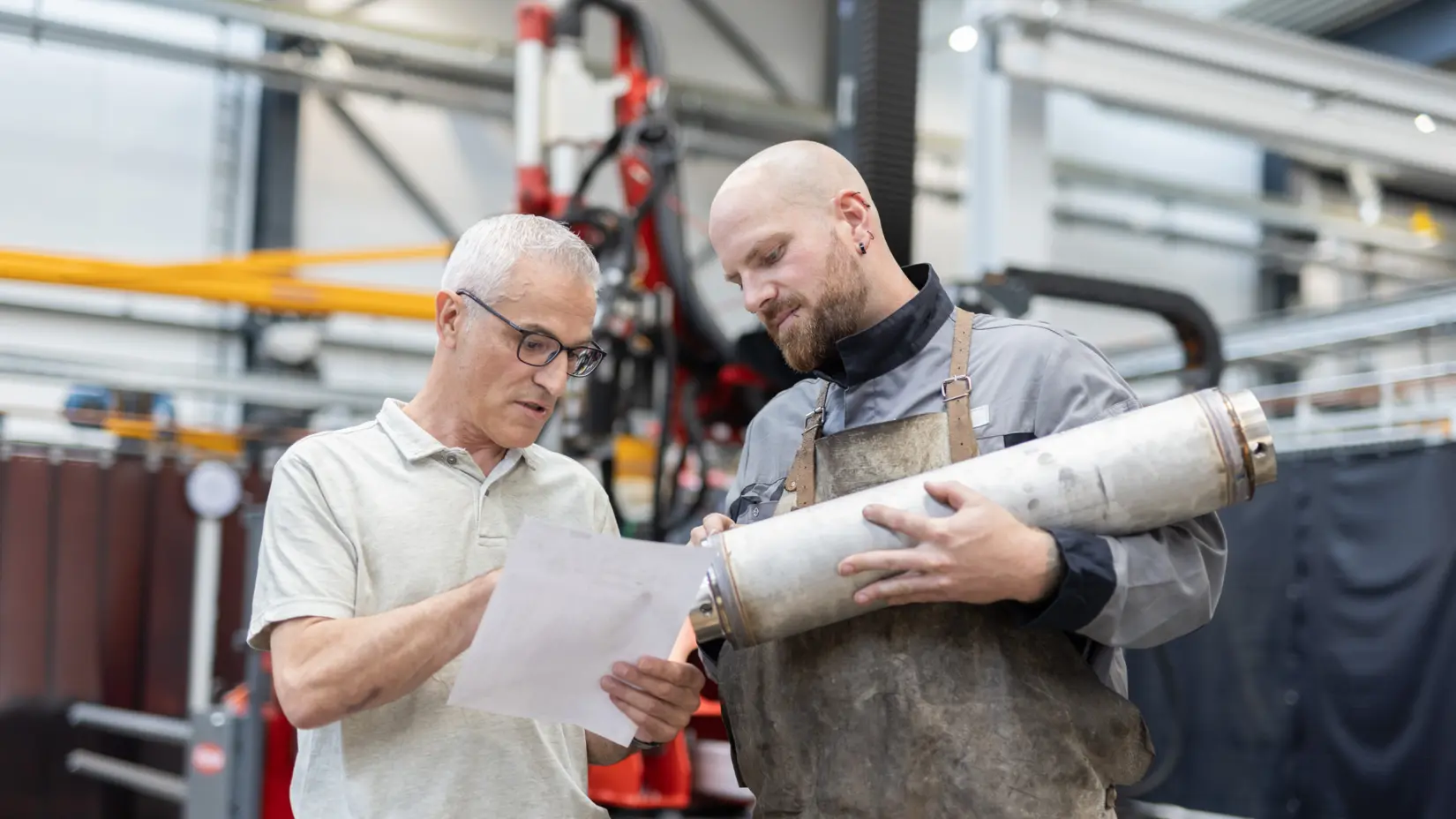 Mitarbeitende bei NETZSCH analysieren technische Pumpe in moderner Werkstatt, Fokus auf Teamarbeit und Innovation.