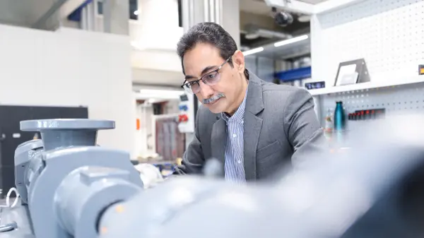 Peter Samraj, Global Product Line Manager NEMO®, inspects large industrial progressing cavity pump in modern manufacturing facility for NETZSCH.